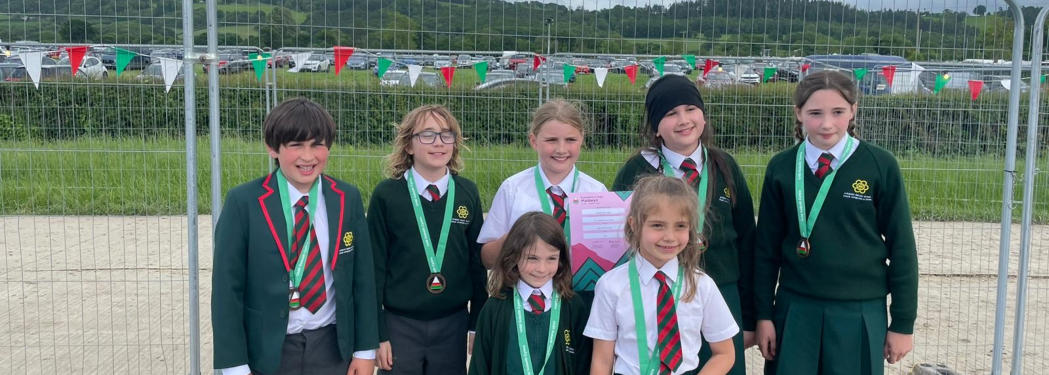 Disgyblion Ysgol Gymraeg Llundain mewn gwisg ysgol gyda medalau